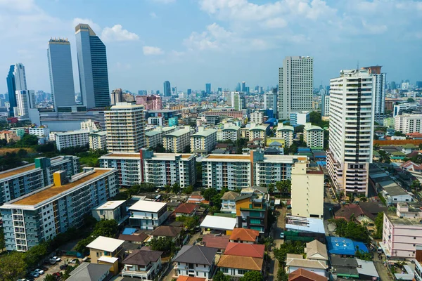 View from the high floor of the streets of Bangkok. Tall buildings and roofs of small houses. City landscape.