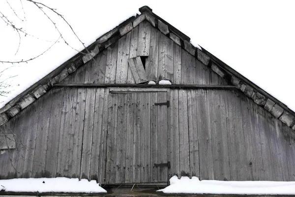 老旧的村舍 从阁楼外面的木板看去 屋顶上覆盖着雪 — 图库照片
