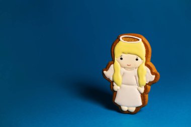 Mavi arka planda şirin meleklerin kurabiyesi. Geleneksel Noel yemeği. Noel ve yeni yıl tatili konsepti. Kopyalama alanı.