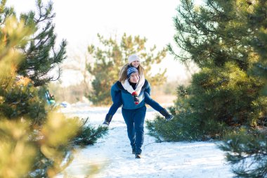Sevgili çift kışın ormanda oynarlar. Kız, Noel ağacının arkasında bir erkeğe biniyor. Gül ve iyi vakit geçir..