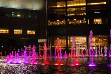 Dans eden çok renkli fıskiyelerin gece görüşü. Şarkı Söyleyen Çeşmeler Şovu. Kuala Lumpur / Malezya - 02.27.2020