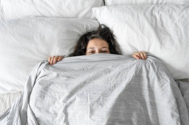 Kız sabahleyin yataktan kalkmak istemiyordu. Battaniyeye saklanmak. Yukarıdan bak. Yatakta pusu..