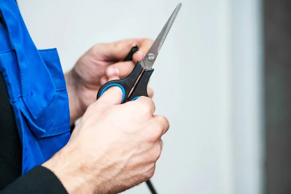 Professional window repair and installation technician, cuts sealing rubber for installation in a pvc window.