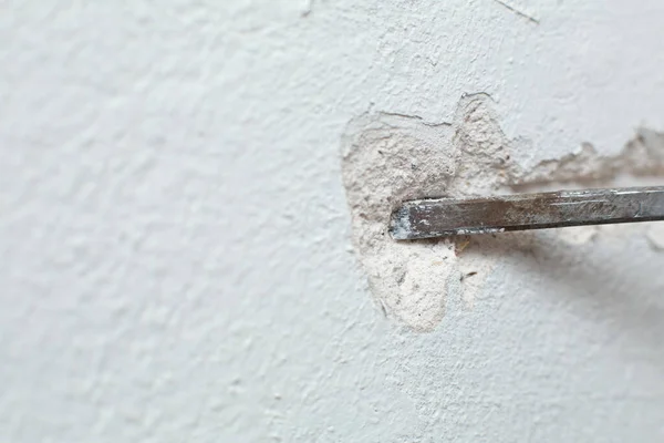 房地维修 一个人挖沟渠 把电缆敷设在墙上 在墙上敷设电线 — 图库照片