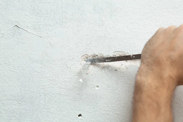 房地维修 一个人挖沟渠 把电缆敷设在墙上 在墙上敷设电线 — 图库照片
