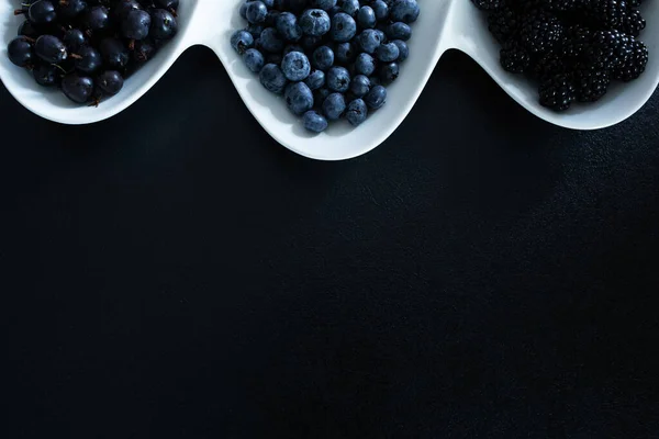 Conjunto Diferentes Tipos Bayas Negras Plato Blanco Sobre Una Mesa — Foto de Stock