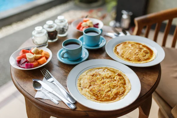 Teller Mit Bananenpfannkuchen Tropischen Früchten Und Zwei Tassen Kaffee Auf — Stockfoto