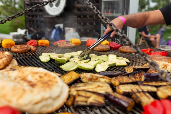 焼き色野菜や新鮮な肉ソーセージを調理する石炭に大きな丸焼き フードフェスティバルでの調理のための食品や設備 — ストック写真