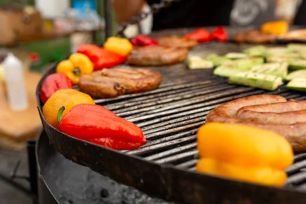 焼き色野菜や新鮮な肉ソーセージを調理する石炭に大きな丸焼き フードフェスティバルでの調理のための食品や設備 — ストック写真