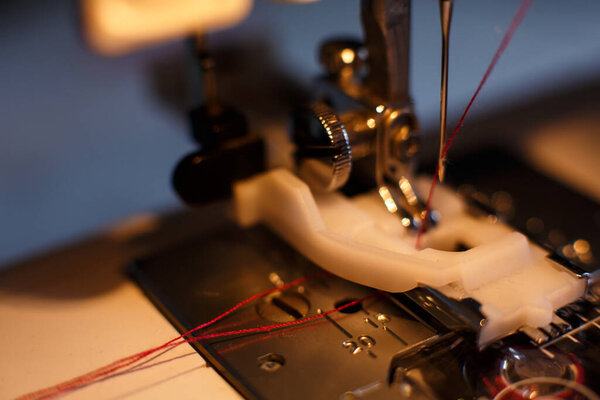 Close-up of a sewing machine with light on. workplace tailor. sewing industry.