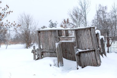 Kışın tarlada tahtalardan terk edilmiş eski bir bina..