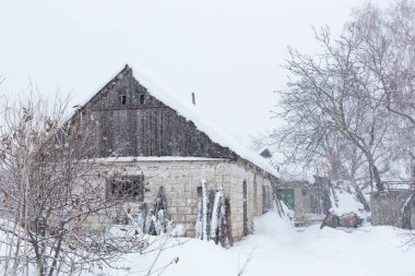Kış, harap olmuş eski ahır. Etrafta çok kar var..