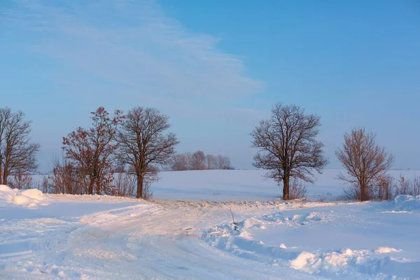 Winter poorly cleared road. Road in the countryside strewn with snow. Winter landscape with snowdrifts.