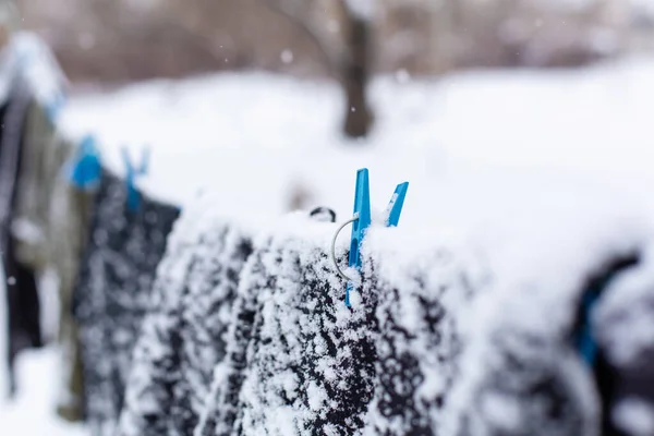 Kış Giysiler Sokakta Kuruyor Sıkıştırılmış Bir Iple Karla Kaplı Giysiler — Stok fotoğraf