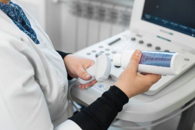 Doktor bir hastanın teşhisi için ultrason makinesi hazırlayın. Doktor ultrason dönüştürücüsüne medya jeli koydu..
