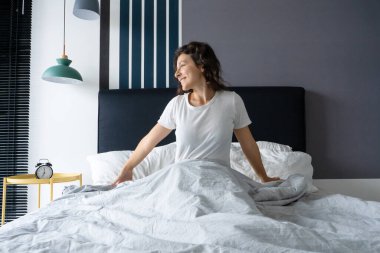 Güzel bir kız şık bir dairede iyi bir ruh hali içinde uyanır. Güne başlarken gülümseyerek esniyor.