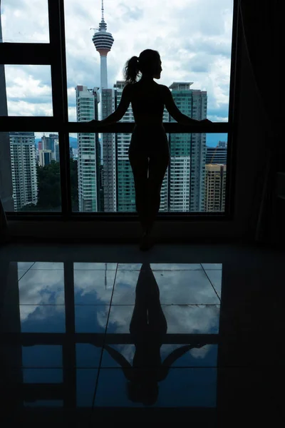 Una Chica Delgada Está Mirando Ciudad Través Una Gran Ventana —  Fotos de Stock