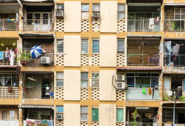 Bir apartmanın balkonlarında giysiler asılıdır. Fakir bölge. Sıradanlık Anları. Kuala Lumpur / Malezya - 06.18.2020