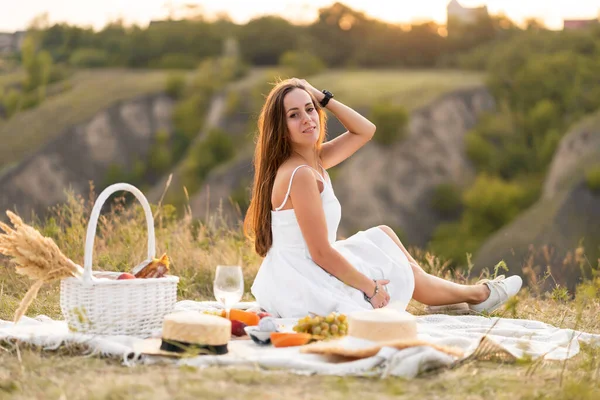 美しい場所でピクニックをしている白いサンドレスの豪華な若いブルネットの女の子 ロマンチックなピクニック — ストック写真