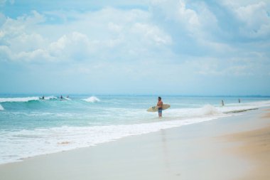 Adam okyanusta sörf tahtasında yüzüyor. Yaz mesleğinde sağlıklı, aktif bir yaşam tarzı. Bali, Endonezya - 03 / 24 / 2018