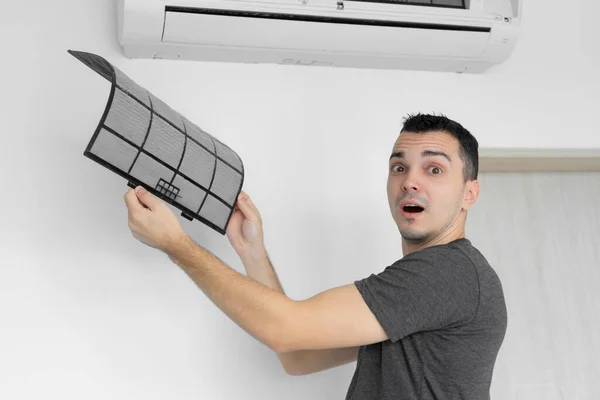 这家伙把家用空调的过滤器从灰尘中清除掉 非常脏的空调过滤器 气候设备护理 — 图库照片