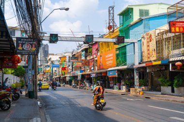 Asya şehrinin her zamanki caddesi. Çok renkli alçak binalar ve motosikletler. Bangkok / Tailand - 02.04.2020