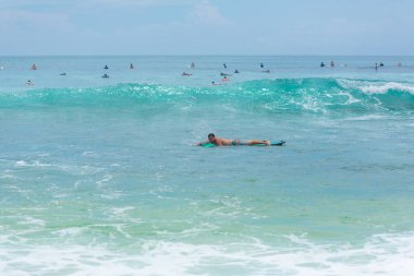 Adam okyanusta sörf tahtasında yüzüyor. Yaz mesleğinde sağlıklı aktif yaşam tarzı