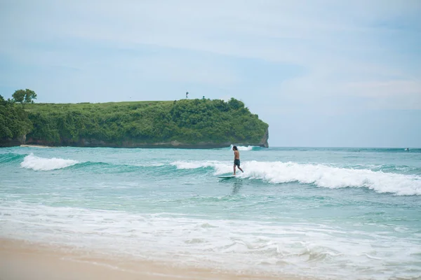 男は海のサーフボードで泳いでいる 夏の職業で健康的なアクティブなライフスタイル バリ島 インドネシア 2018 — ストック写真