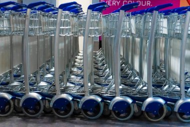 Havaalanı binasında bavul taşımak için sıra sıra yük arabaları.