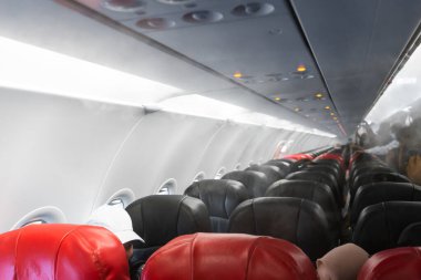 Kalkıştan önce uçak kabini. Uçağa binen yolcular. Koronavirüs salgını sırasında hava yolculuğu