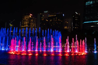 Dans eden çok renkli fıskiyelerin gece görüşü. Şarkı Söyleyen Çeşmeler Şovu. Kuala Lumpur / Malezya - 04.27.2020
