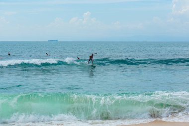 Adam okyanusta sörf tahtasında yüzüyor. Yaz mesleğinde sağlıklı, aktif bir yaşam tarzı. Bali, Endonezya - 03 / 24 / 2018