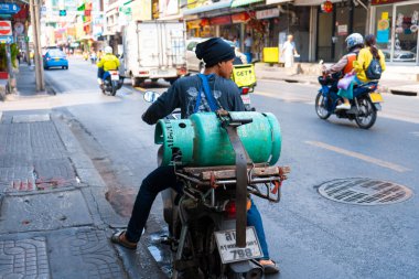 Motosiklette bir adam gaz tüpü taşıyor. Tayland 'a gaz tüpleri teslimatı. Bangkok / Tailand - 02.04.2020