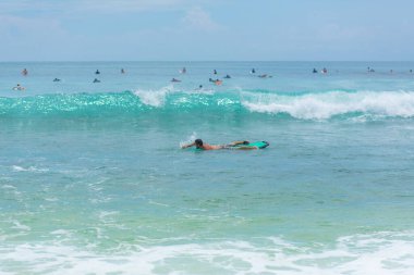 Adam okyanusta sörf tahtasında yüzüyor. Yaz mesleğinde sağlıklı aktif yaşam tarzı