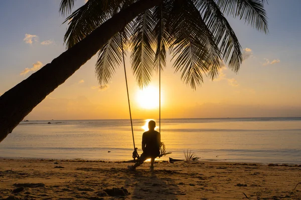 Der Mann Genießt Den Sonnenuntergang Auf Einer Schaukel Tropischen Strand — Stockfoto