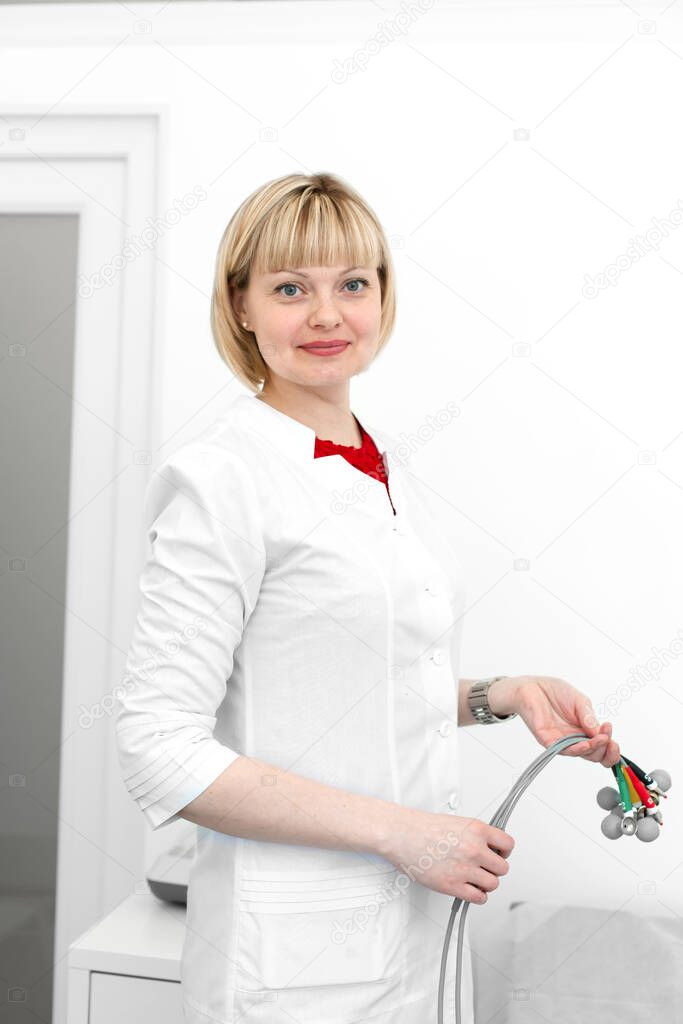 Portrait of a woman doctor cardiologist with cardiograph electrodes in her hands.