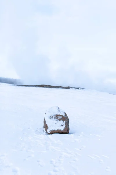 アイスランドの冬に雪で覆われた碑文間欠泉と石の標識 — ストック写真