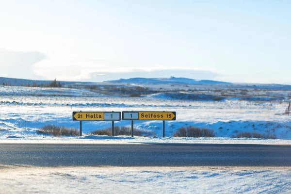 Fork road sign directions path in iceland in winter.