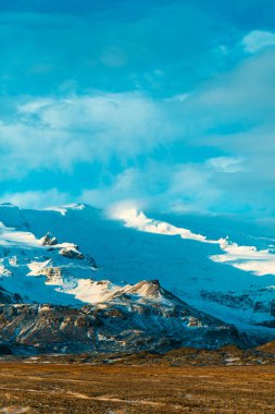 İzlanda 'nın inanılmaz manzaraları. Karla kaplı dağlar ve buzullar. Gün batımı