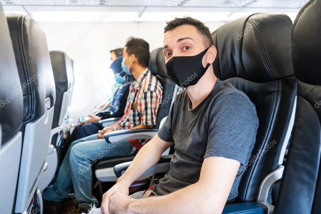 Airplane passengers are wearing medical masks on their faces. Air travel during the coronavirus pandemic. Airlines requirements