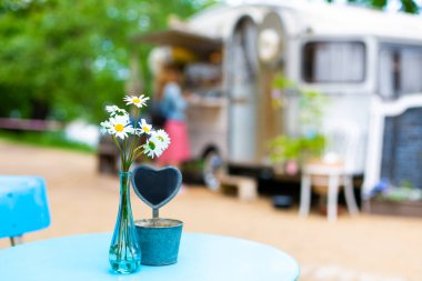 Yazlık bir kafede açık hava masasının açık romantik atmosferi. Hipster bir kafede vazo masasında canlı papatyalar..