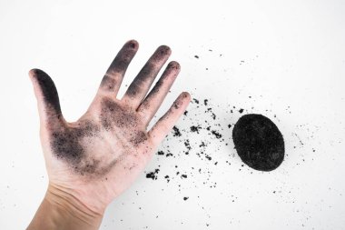 Kül içinde eski bir ördek yumurtası tarifi. Beyaz arka planda kül içinde tuzlu ördek yumurtası. Bir yumurtayla küle bulanmış bir el.