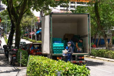 Dükkanlara mal teslimatı. Kamyondan kutular dolusu içki boşaltılıyor. Kuala Lumpur / Malezya - 04.17.2020