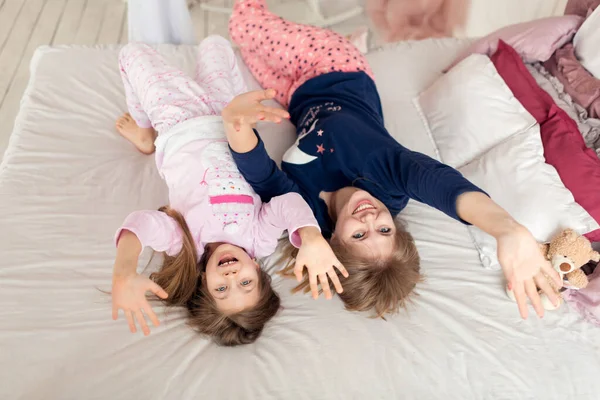 Küçük kız yatakta yatarken annesiyle vakit geçiriyor..