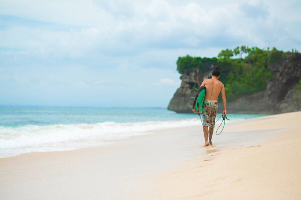 Surfer. Surfing Man With Surfboard Walking On Sandy tropical Beach. Healthy Lifestyle, water activities, Water Sport. Beautiful Ocean