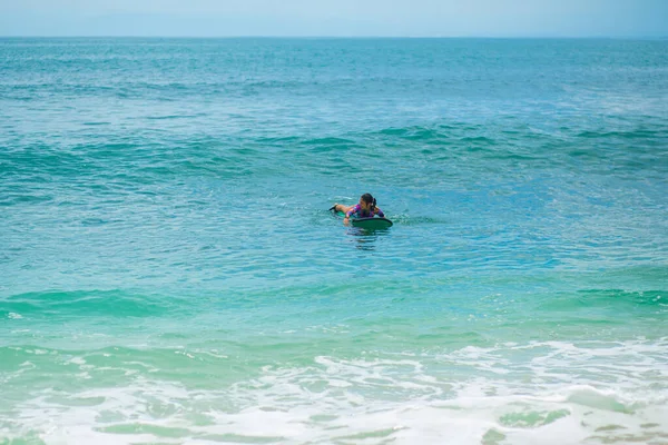 性感瘦小的女孩骑在海浪冲浪板上在海里 暑期健康积极的生活方式 — 图库照片