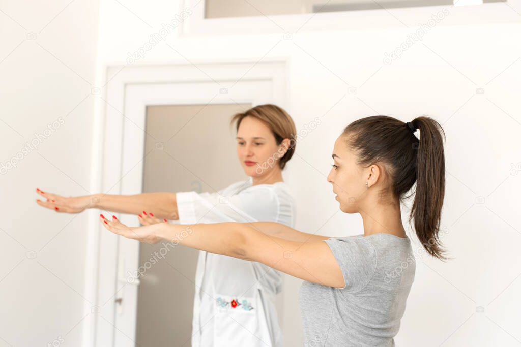 young woman professional short-haired general practitioner in a bright medical room examines a patient.