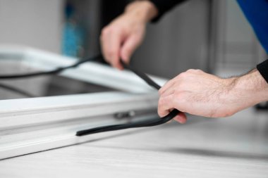 Pencerelerin onarımı ve kurulumunda profesyonel usta, pvc pencerelerindeki lastik contaları değiştirir.