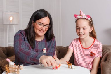 Psikoterapistin resepsiyonundaki genç kız. Çocuklar için psikoterapi seansı. Psikolog hastayla birlikte çalışıyor. Kız, doktor terapistle oyuncak hayvancılık oynuyor..