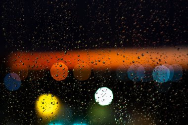 Pencerelere su damlaları ve günbatımında şehir batımları.